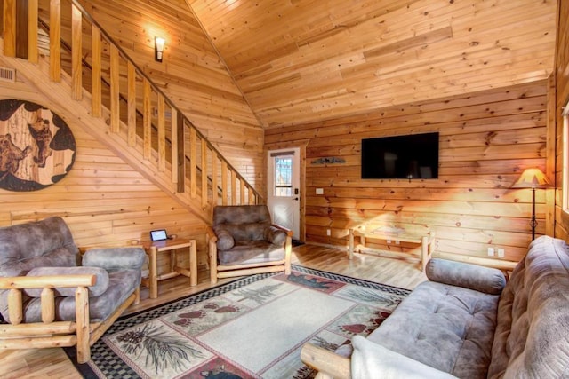 living room featuring lofted ceiling, wood ceiling, wooden walls, and light hardwood / wood-style floors