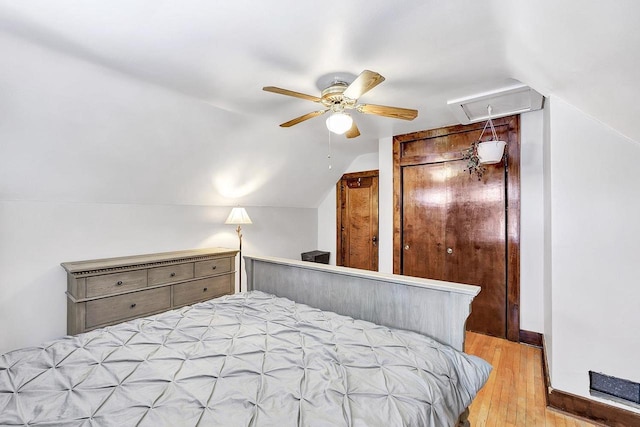 bedroom featuring ceiling fan, lofted ceiling, and light hardwood / wood-style flooring