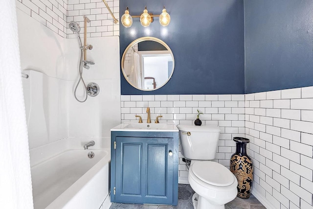 full bathroom featuring tiled shower / bath, vanity, toilet, and tile walls