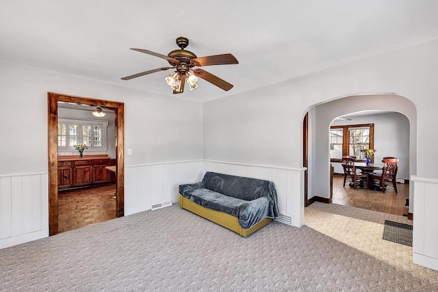 sitting room featuring ceiling fan, a healthy amount of sunlight, and carpet