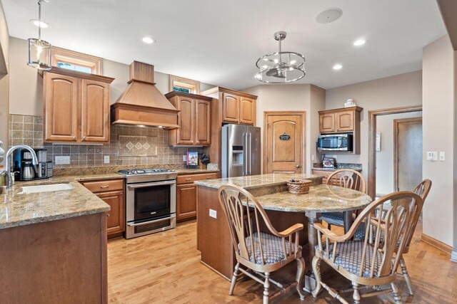6507 Willow Ct, Waterford, WI 53185 - kitchen with pendant lighting, appliances with stainless steel finishes, sink, and premium range hood