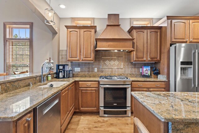 6507 Willow Ct, Waterford, WI 53185 - kitchen with premium range hood, sink, tasteful backsplash, stainless steel appliances, and light stone countertops