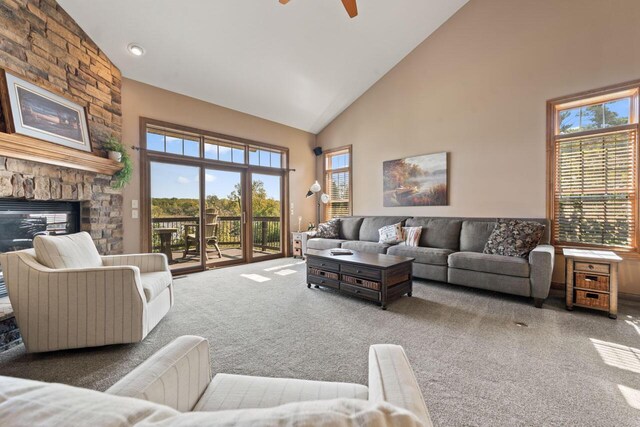 6507 Willow Ct, Waterford, WI 53185 - living room with dark carpet, a stone fireplace, high vaulted ceiling, and ceiling fan