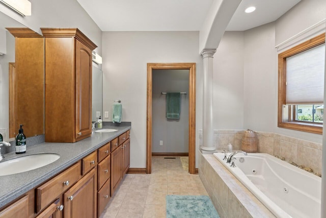 6507 Willow Ct, Waterford, WI 53185 - bathroom with ornate columns, vanity, tiled tub, and tile patterned floors