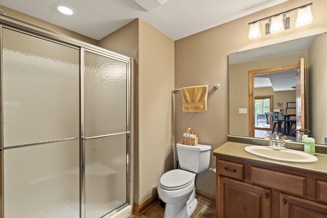 6507 Willow Ct, Waterford, WI 53185 - bathroom featuring a shower with door, vanity, tile patterned floors, and toilet
