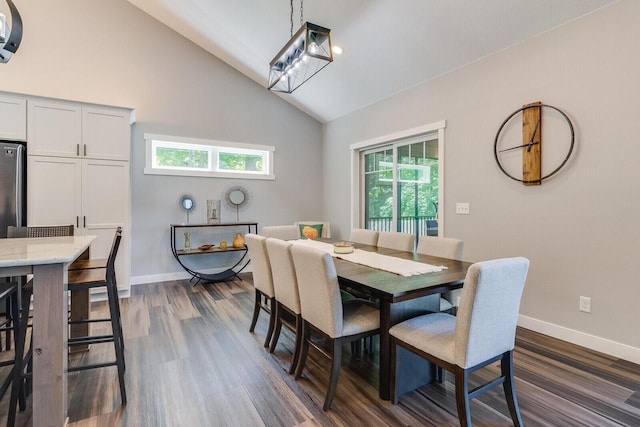 dining room with high vaulted ceiling, dark wood finished floors, and baseboards