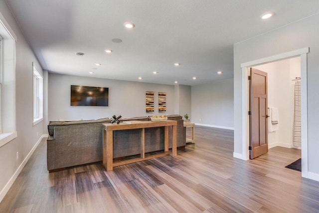 living area with baseboards, wood finished floors, and recessed lighting