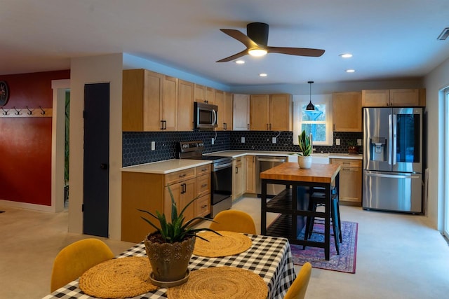 kitchen with appliances with stainless steel finishes, decorative backsplash, ceiling fan, and decorative light fixtures