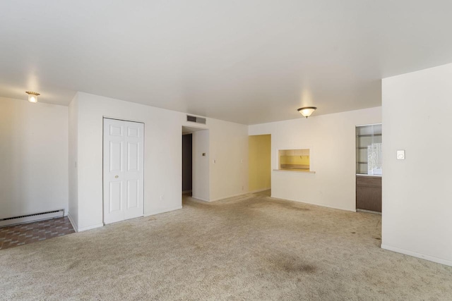 carpeted empty room with a baseboard heating unit