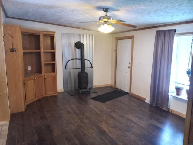 33315 State Highway 13, Bayfield, WI 54814 - workout room featuring a wood stove, dark wood-style flooring, ceiling fan, ornamental molding, and a textured ceiling