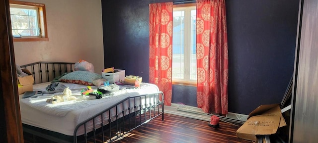 bedroom featuring multiple windows and dark hardwood / wood-style floors