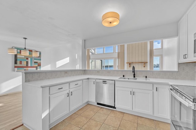 kitchen with stainless steel appliances, sink, white cabinets, and kitchen peninsula