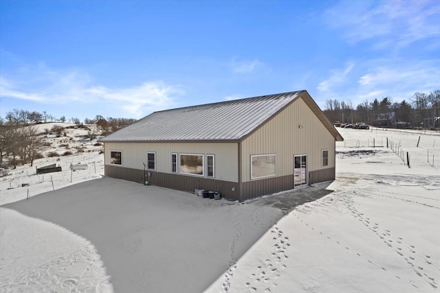 view of snow covered back of property