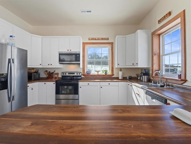 kitchen featuring stainless steel appliances, sink, and white cabinets