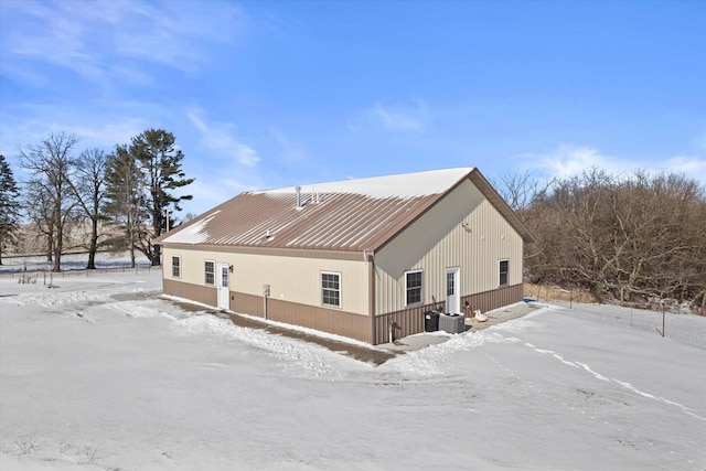 snow covered house featuring cooling unit