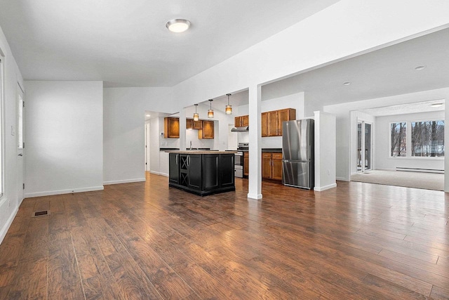 unfurnished living room featuring a sink, baseboard heating, visible vents, baseboards, and dark wood-style flooring