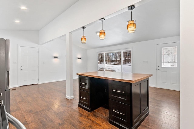 kitchen featuring a center island, baseboards, hanging light fixtures, and dark wood finished floors