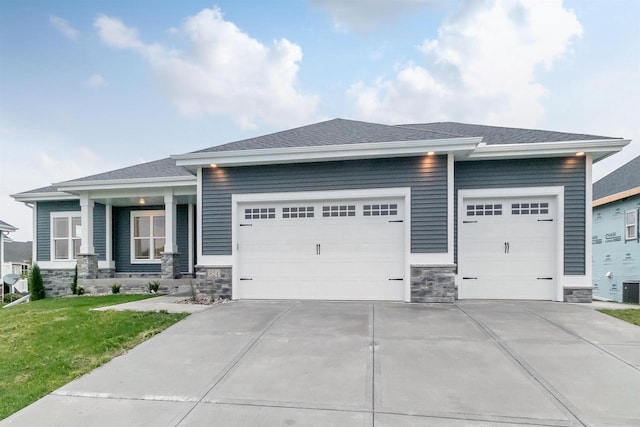 prairie-style house with a garage, a front yard, and central air condition unit