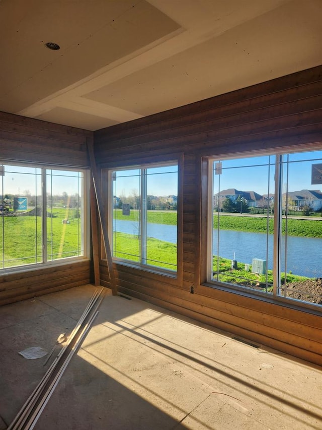 unfurnished sunroom featuring a water view