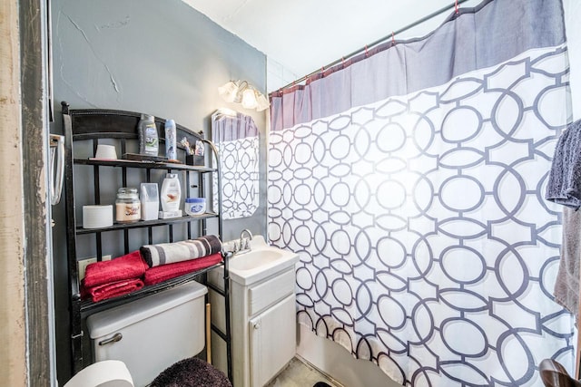 bathroom featuring toilet, shower / bath combo with shower curtain, and vanity