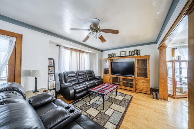 living area with ornamental molding, ornate columns, ceiling fan, and light wood finished floors