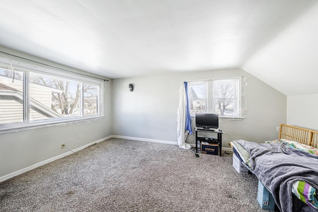 carpeted bedroom with lofted ceiling and baseboards