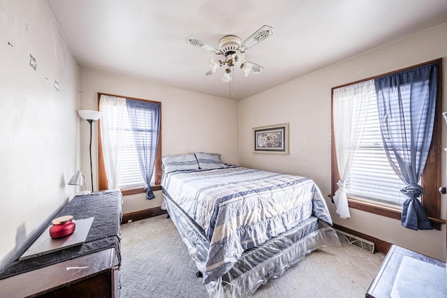 bedroom featuring baseboards, visible vents, a ceiling fan, and light colored carpet