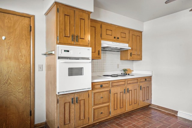 kitchen with decorative backsplash, white appliances, and a baseboard radiator