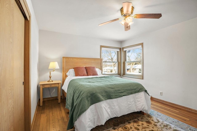 bedroom with ceiling fan, a closet, and wood-type flooring