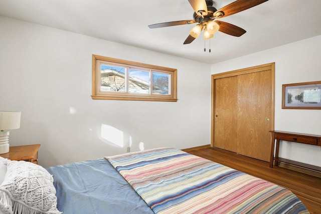 bedroom with ceiling fan, dark hardwood / wood-style floors, and a closet