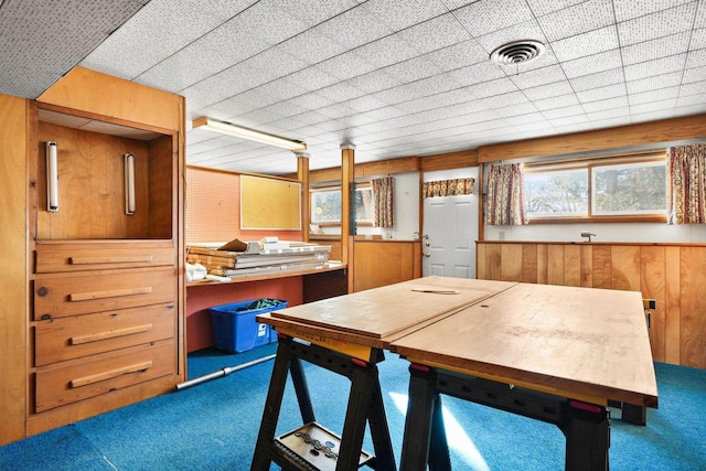 dining space with wooden walls and carpet floors