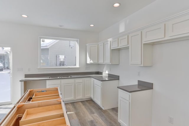 kitchen featuring white cabinetry, sink, and light wood-type flooring