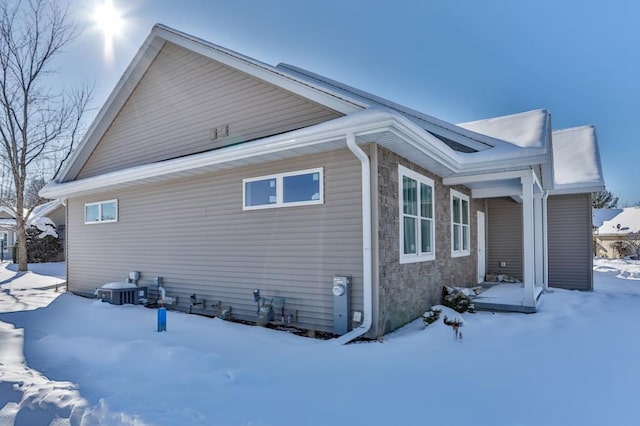 snow covered property featuring central AC unit