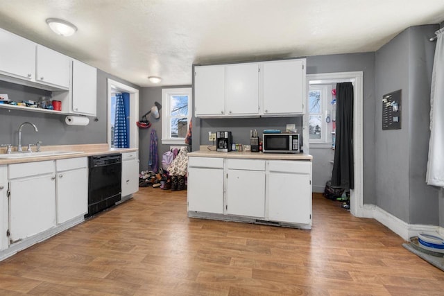 kitchen with white cabinetry, dishwasher, sink, and light hardwood / wood-style flooring