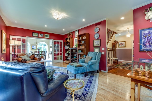 living room featuring crown molding, hardwood / wood-style floors, and a notable chandelier