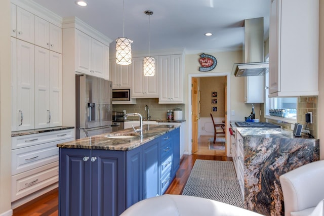 kitchen with blue cabinets, hanging light fixtures, stainless steel appliances, range hood, and white cabinets