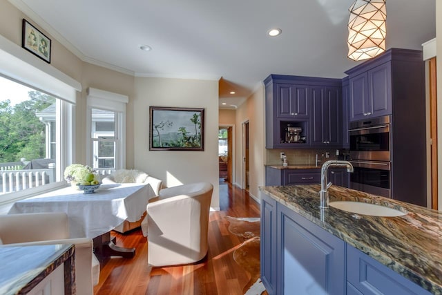 kitchen with sink, crown molding, double oven, blue cabinets, and decorative backsplash