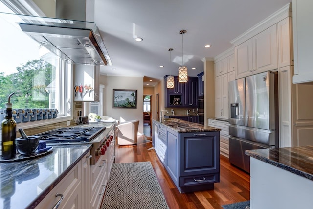 kitchen featuring white cabinetry, decorative light fixtures, stainless steel appliances, and a kitchen island