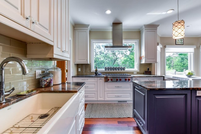 kitchen with stainless steel gas stovetop, white cabinetry, sink, dark stone countertops, and island exhaust hood