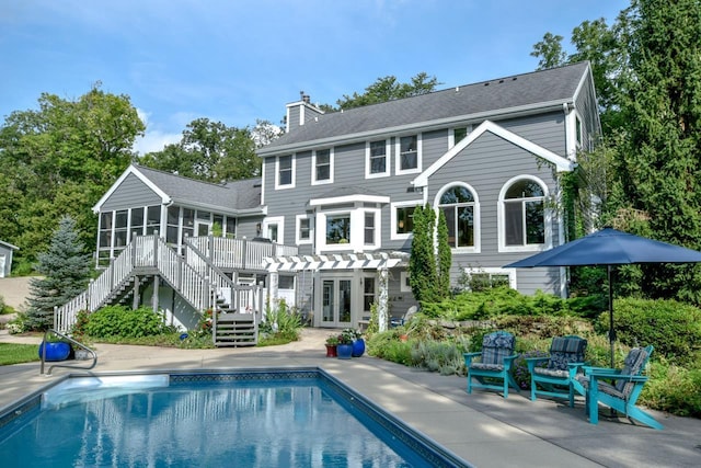 rear view of house featuring a pergola, a sunroom, a patio, and a swimming pool side deck