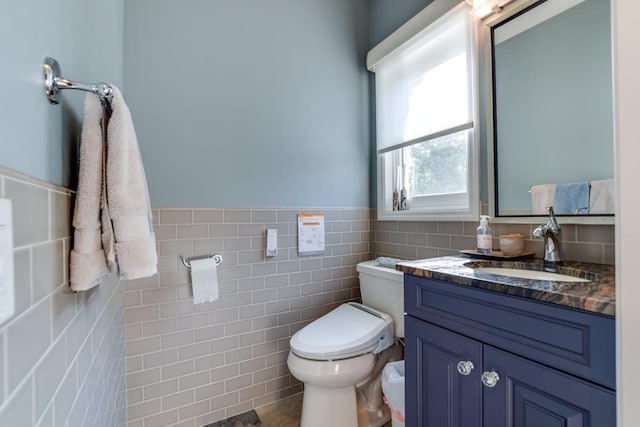 bathroom featuring tile walls, vanity, and toilet