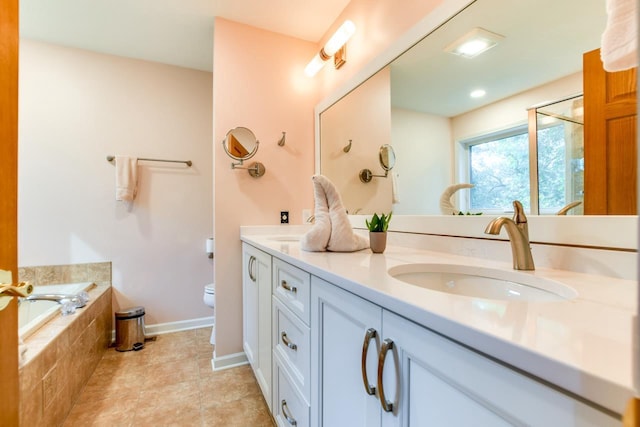 bathroom featuring vanity, tile patterned flooring, tiled bath, and toilet