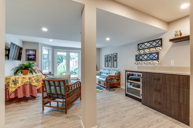 kitchen featuring dark brown cabinets, wine cooler, and light hardwood / wood-style floors