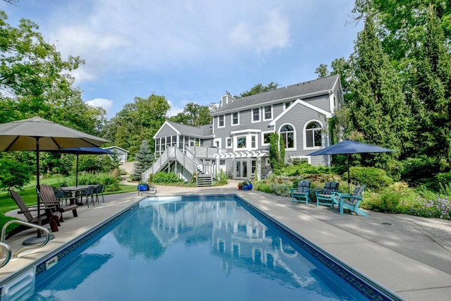 rear view of property featuring a sunroom and a patio area