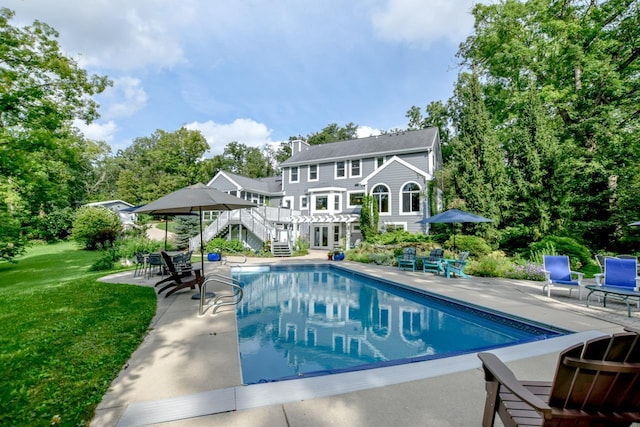 view of swimming pool featuring a lawn and a patio