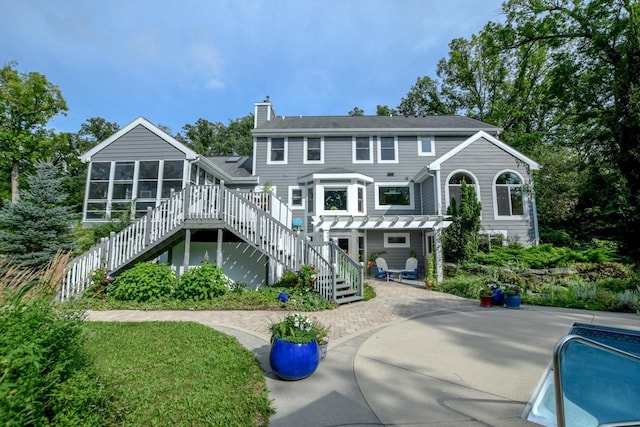 back of house featuring a pergola and a sunroom