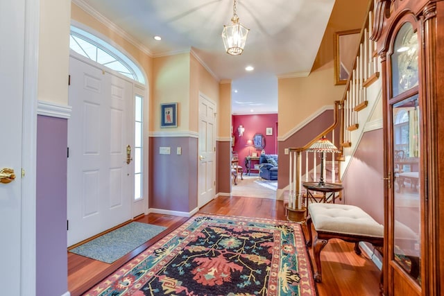 foyer entrance featuring ornamental molding, light hardwood / wood-style floors, and a notable chandelier