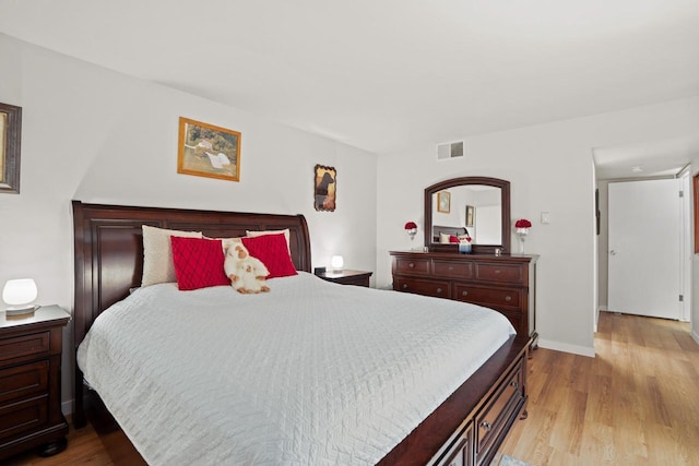 bedroom featuring baseboards, visible vents, and light wood-style floors