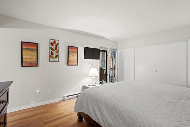 bedroom featuring a baseboard radiator, a closet, baseboards, and wood finished floors