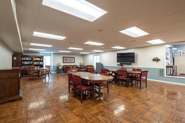 dining room featuring baseboards, visible vents, and a drop ceiling